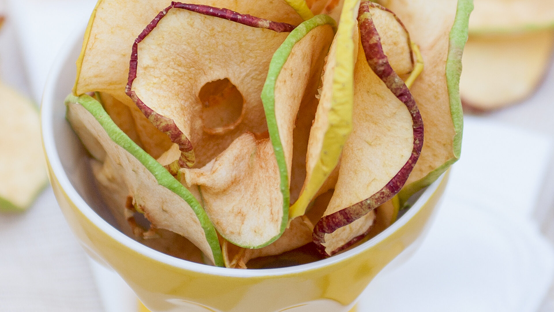 ome fare le mele essiccate in casa: il risultato finale della ricetta, con fette di mela croccanti pronte da gustare.