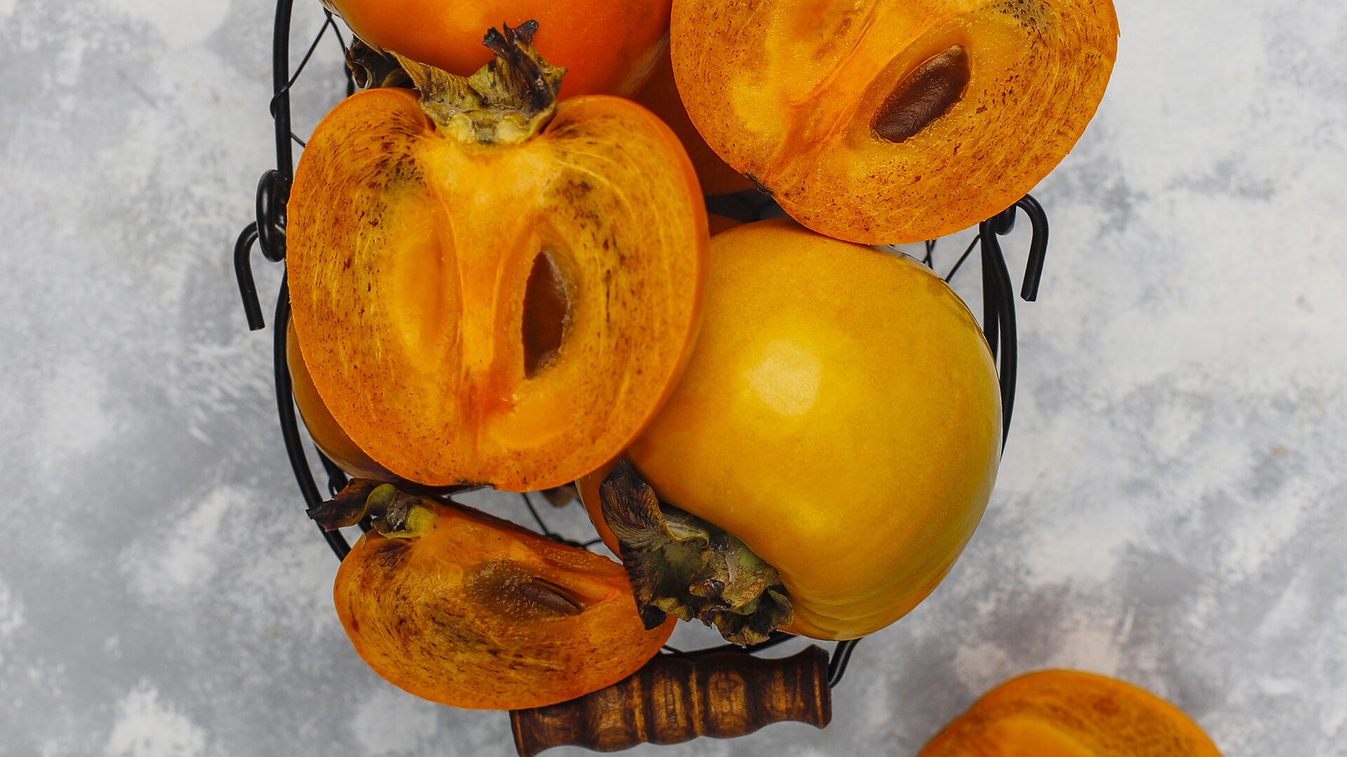 Come essiccare i cachi: fette di caco fresco e il risultato essiccato, una ricetta semplice per preparare uno snack autunnale con l'essiccatore.